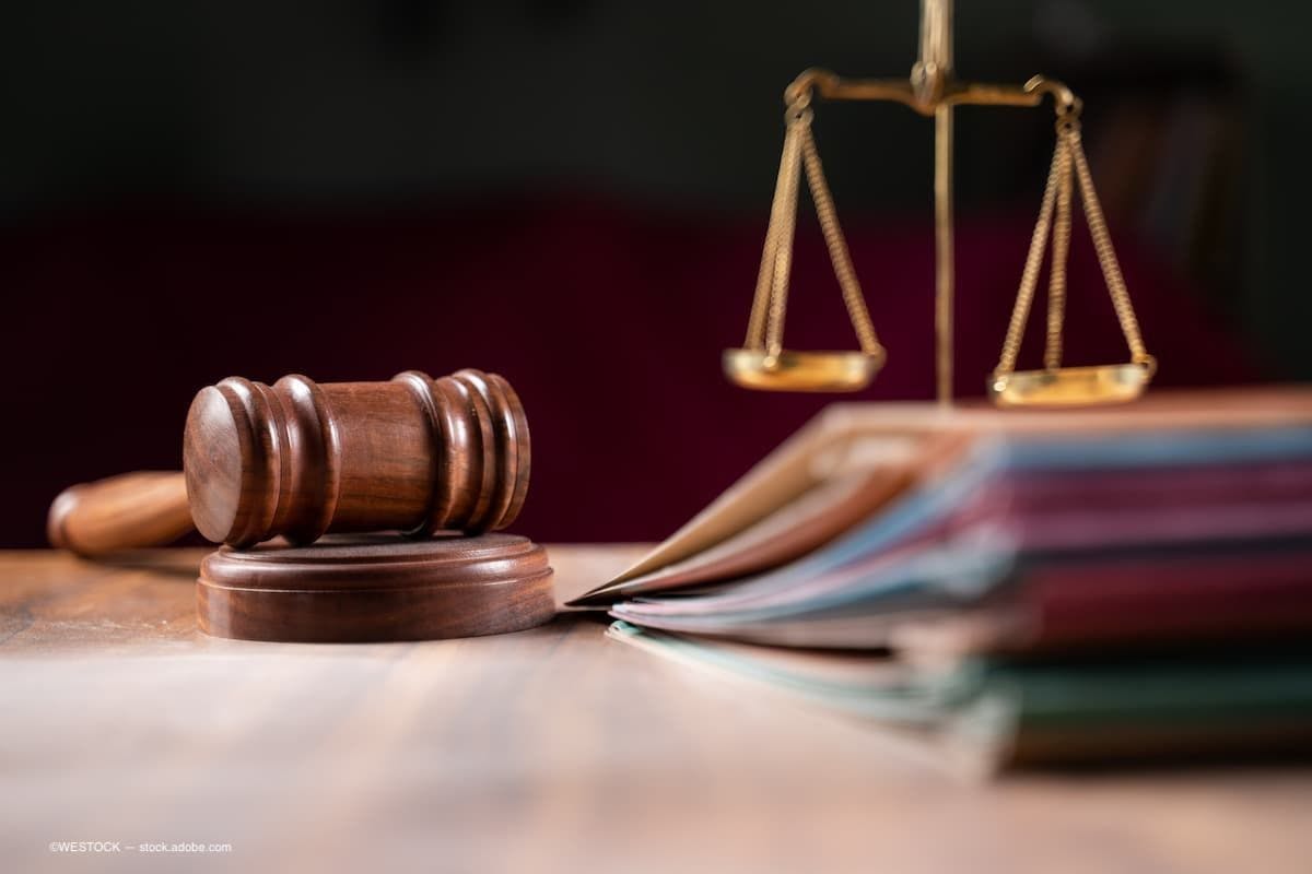 an image of a gavel on a table with legal documents and a scale. (Image Credit: AdobeStock/WESTOCK)