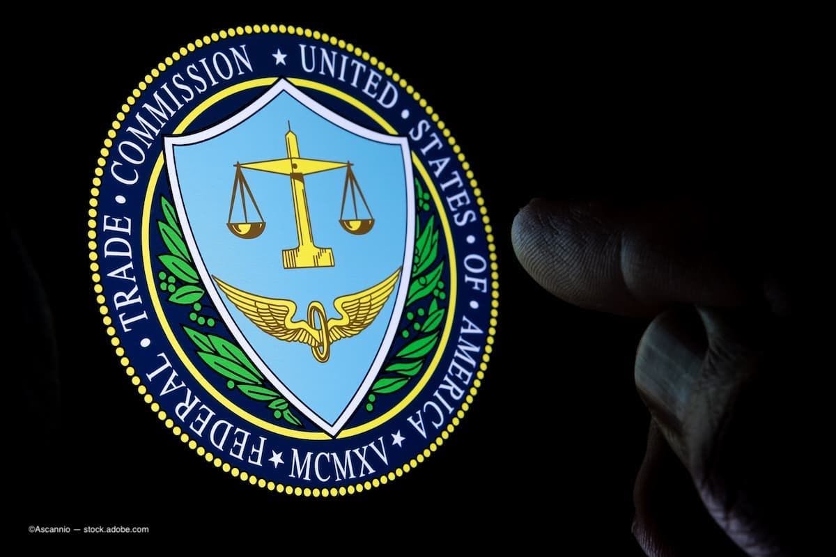 TC Federal Trade Commission of the United States of America logo seen on the display in a dark room and blurred finger pointing at it. (Image Credit: AdobeStock/Ascannio)