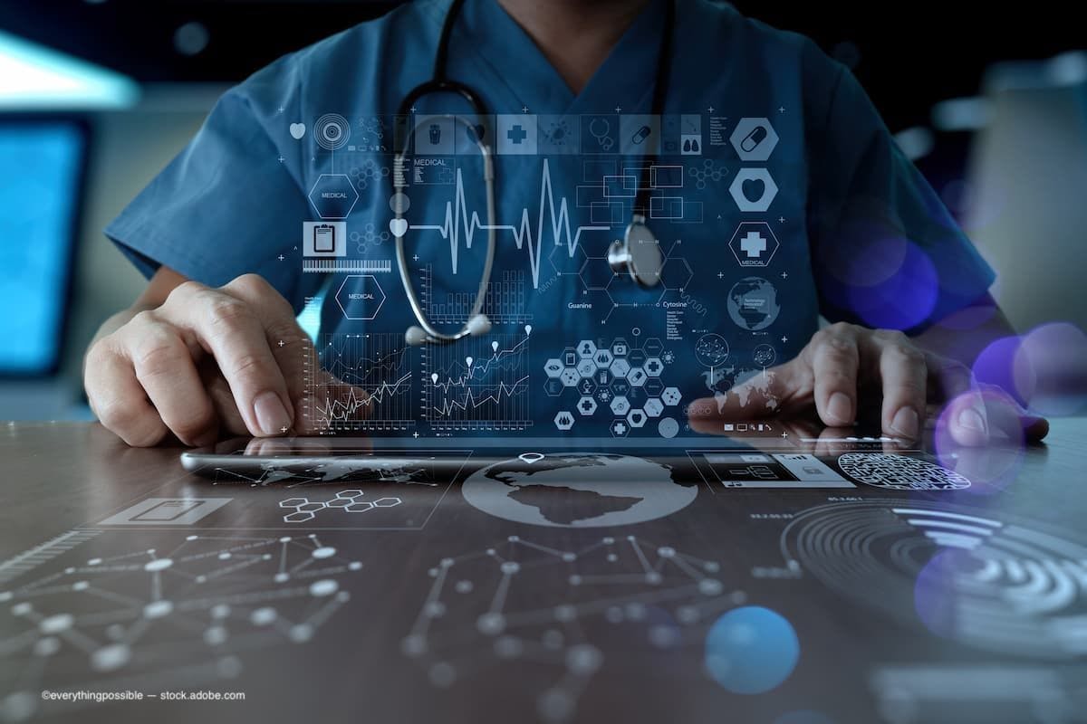 A doctor sitting going over medical data. (Image Credit: AdobeStock/everythingpossible)
