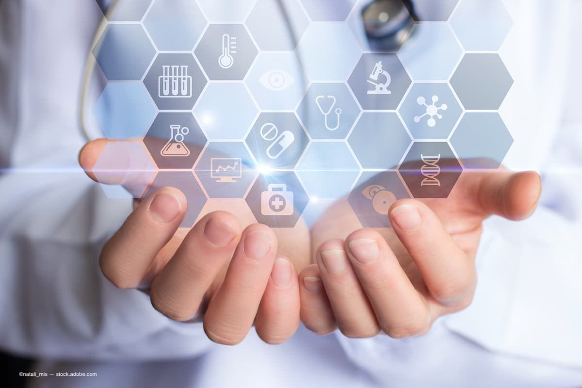 A doctor holding an image of computer generated data and symbols in his hands. (Image Credit: AdobeStock/natali_mis)