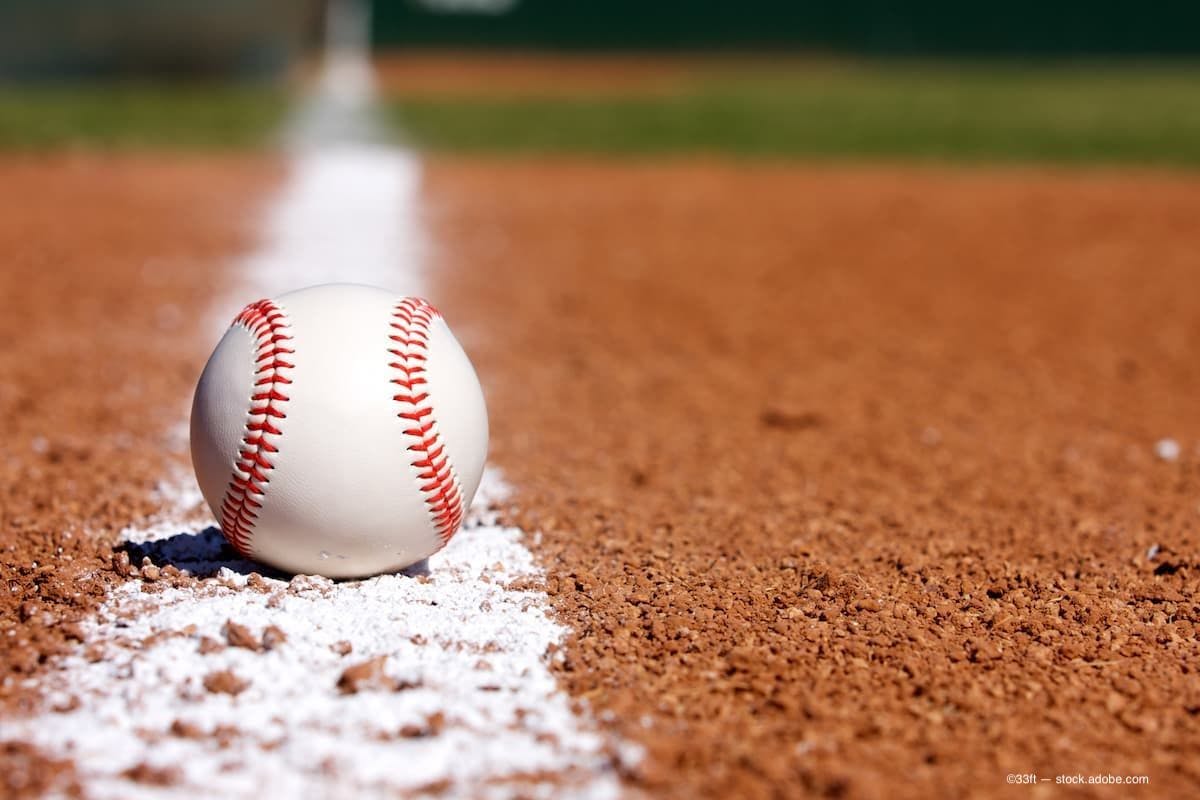 A baseball sitting on the foul line in a baseball diamond. (Image Credit: AdobeStock/33ft)
