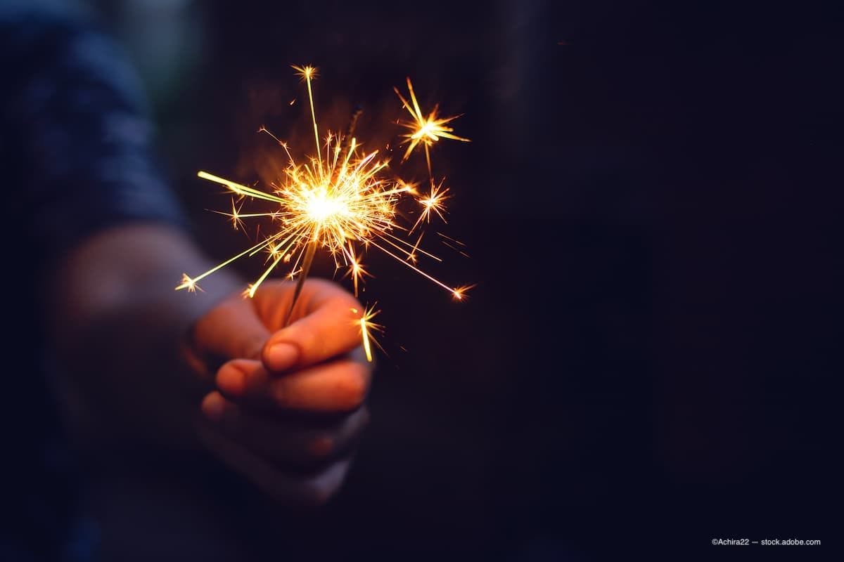 a woman holding a sparkler firework. (Image Credit: AdobeStock/Achira22)