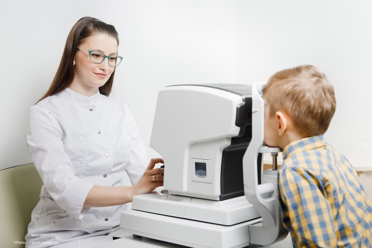 A child sitting at an OCT machine at the eye doctor. (Image credit: AdobeStock/Parilov)