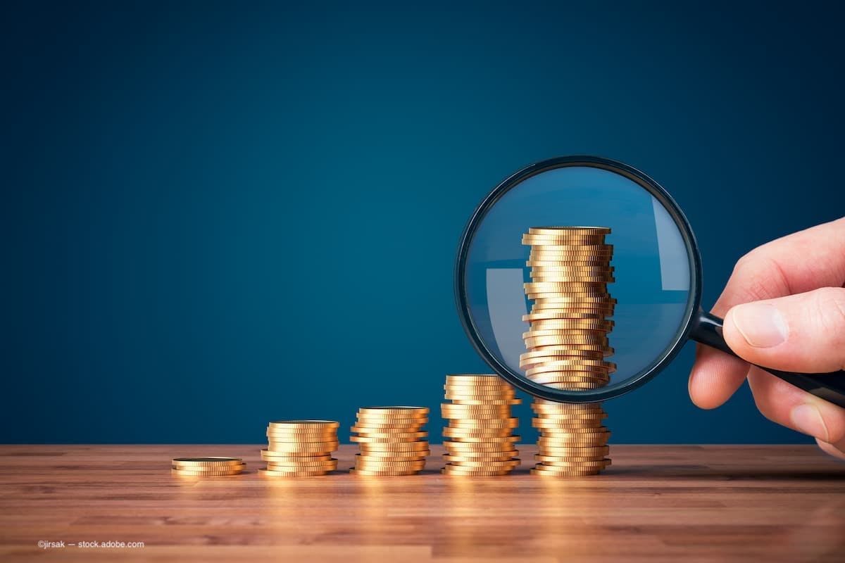 an increasing stack of coins from the left to the right with a magnifying glass on the last stack. (Image Credit: AdobeStock/jirsak) 