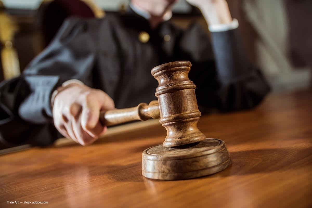 a judge with a gavel in the courtroom. (Image Credit: AdobeStock/de Art)