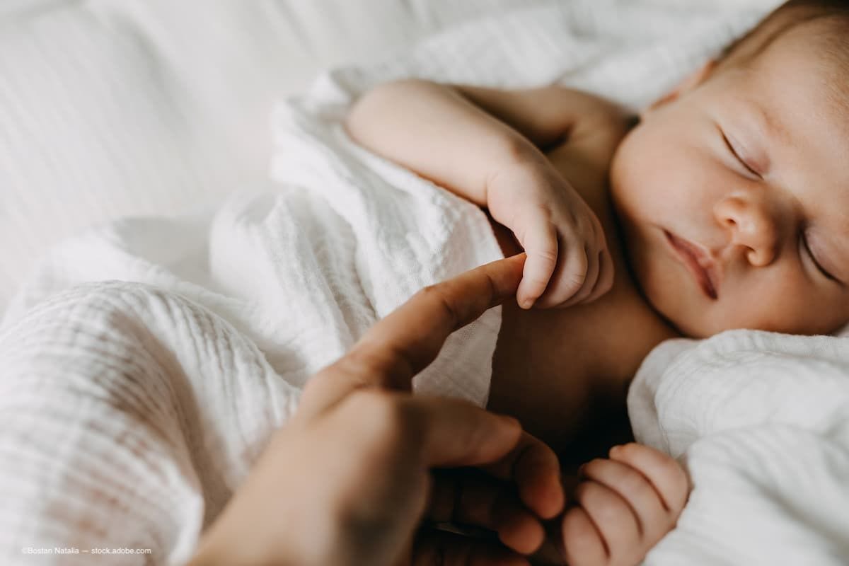 a new born baby laying while holding its mother's finger. (Image Credit: AdobeStock/Bostan Natalia)