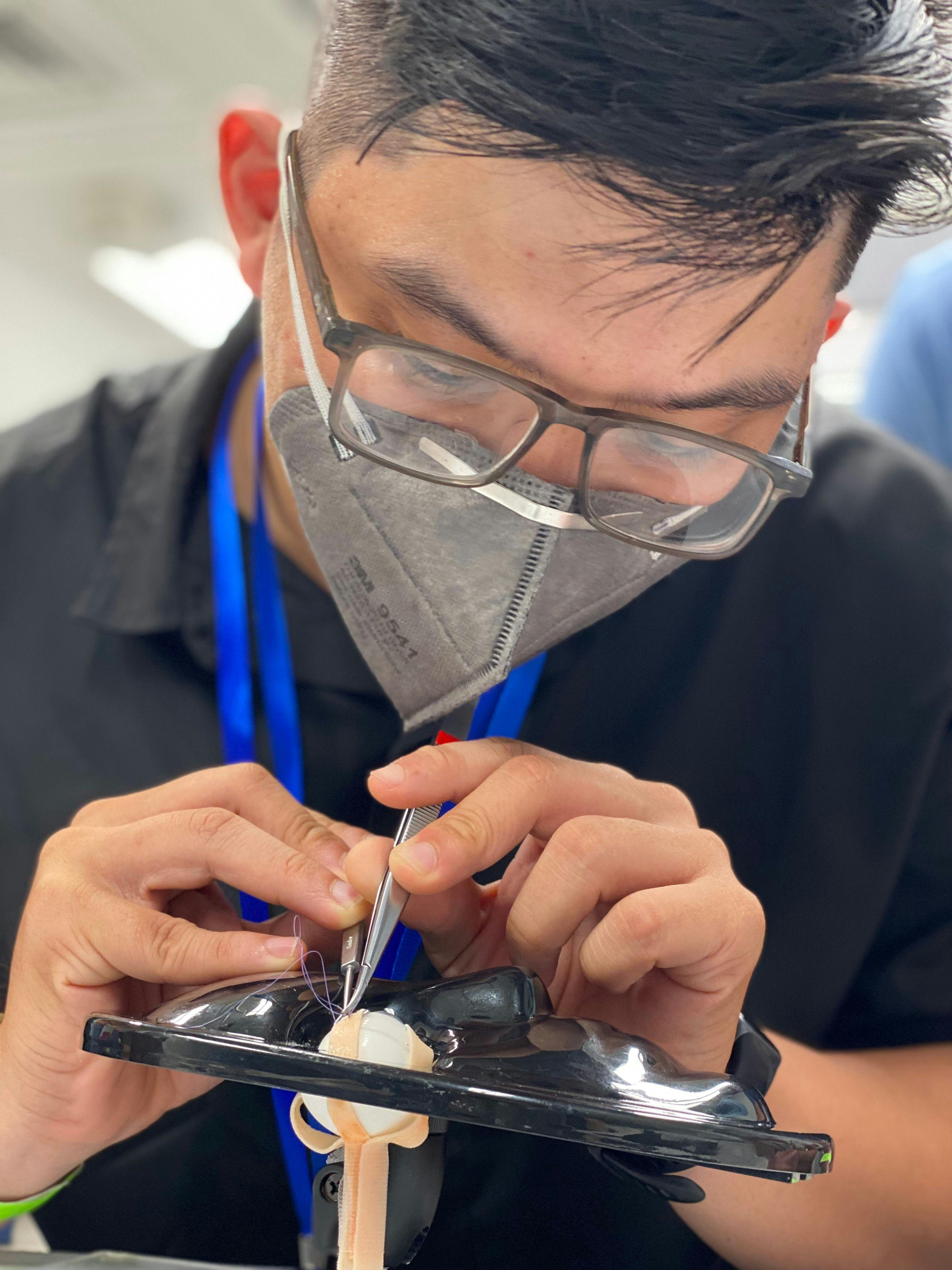 A doctor is practicing strabismus surgery skills on an artificial eye in Can Tho, Vietnam on board the Orbis Flying Eye Hospital. (Image courtesy of Orbis International)