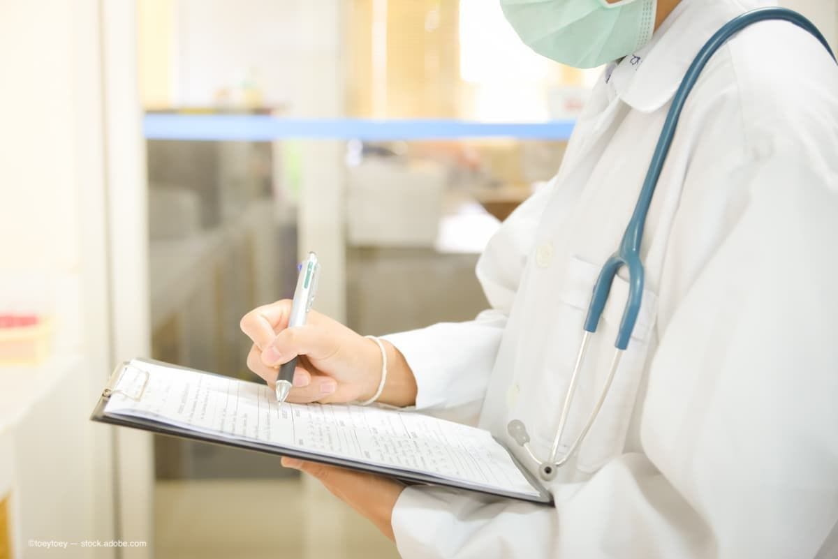 A doctor holding a clipboard full of medical data (Image Credit: AdobeStock/toeytoey)